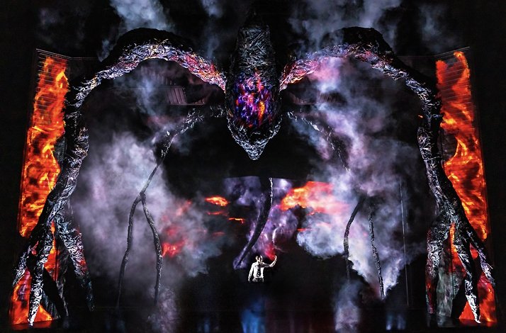Scene from the Broadway's Stranger Things: The First Shadow performance: a giant birdlike creature hovering over person on the stage.