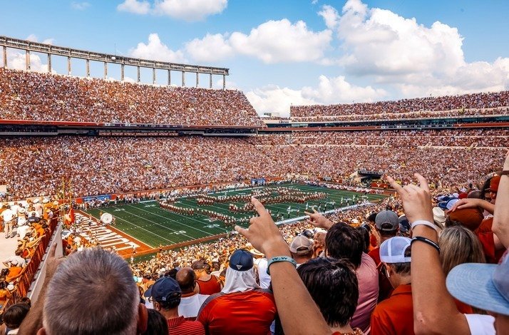 People on the tribunes watching the game at Darrell K Royal-Texas Memorial Stadium.