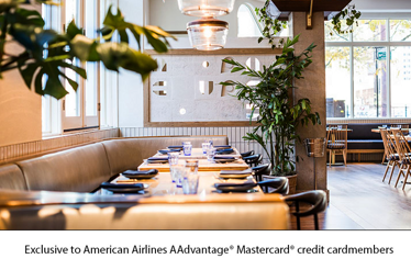 Elegant interior of avec River North with set tables, lush plants, and natural light.