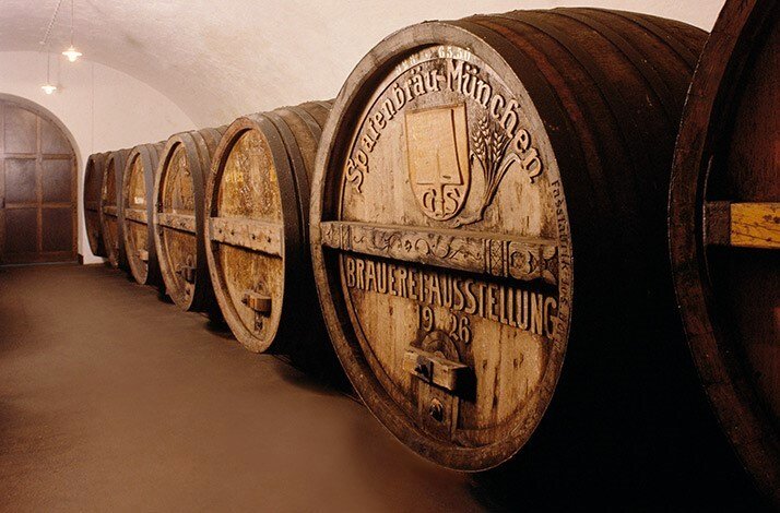 Row of historic carved wooden beer barrels inscribed 