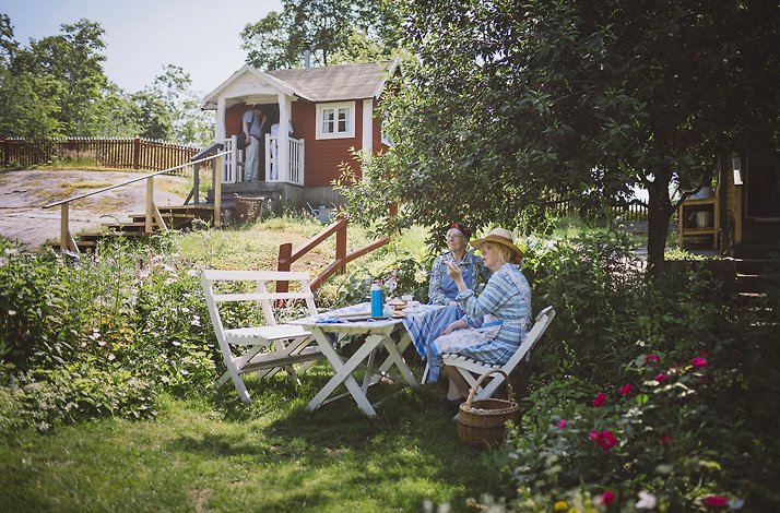 Two people sitting at a wooden table having a meal at the world's oldest open-air museum Skansen