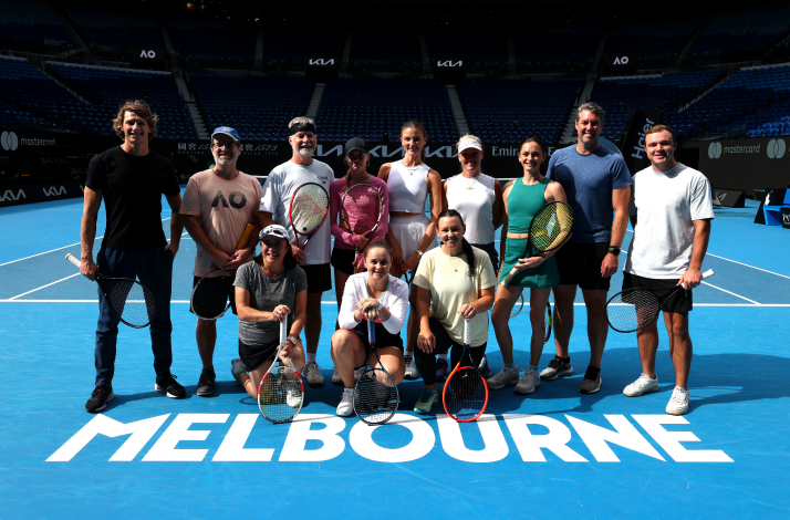 A group of people posing at the field in Rod Laver Arena, Melbourne.