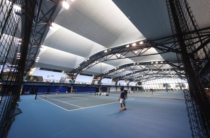 Enter the inner circle at the Australian Open: In Melbourne, Australia Indoor tennis practice courts with players training under a high, modern roof.