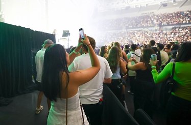 A girl films the Australian Open Live Final Stage on her phone.