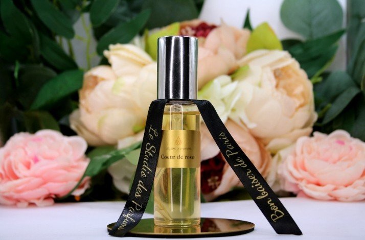 Bottled perfume on the background of flowers.