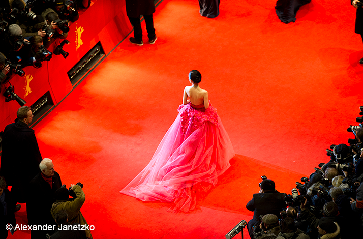 A person in a pink dress walking the red carpet of Berlinale festival© Alexander Janetzko