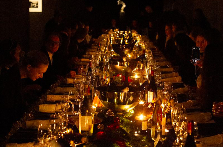 People are enjoying dinner at a beautifully set long table at the Berlinale.