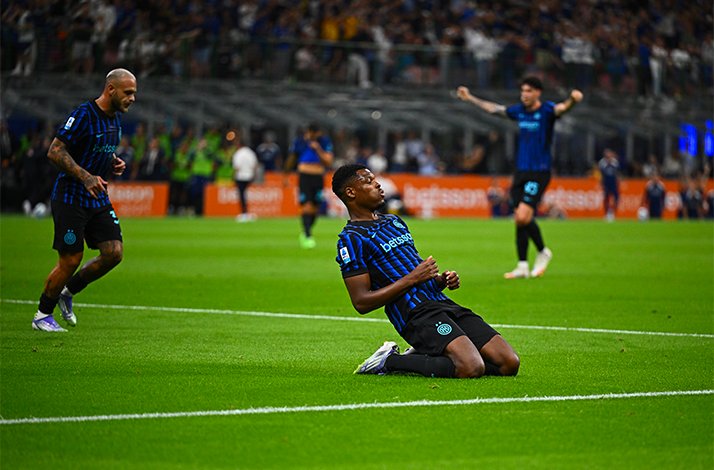  A soccer player sits on the ground, looking contemplative after a play during a match.