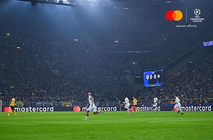 Players in action under floodlights at a packed Signal Iduna Park, scoreboard reading 0–0, Borussia Dortmund v Inter Milan. Mastercard and UEFA Champions League logos at the top right corner.
