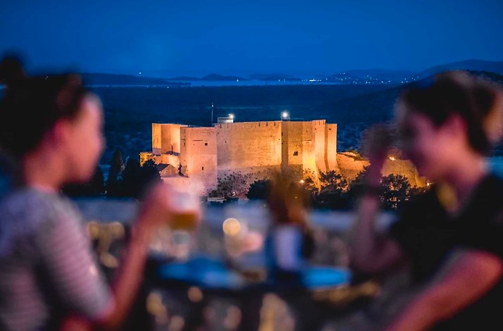 Two people with the St. Michael's Fortress in the background.