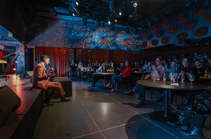 An artist singing with a band indoor of the pub of House of Art Arsen.