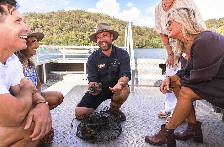 Instructor of pearl farm cruise with participants introducing the experience on a boat.