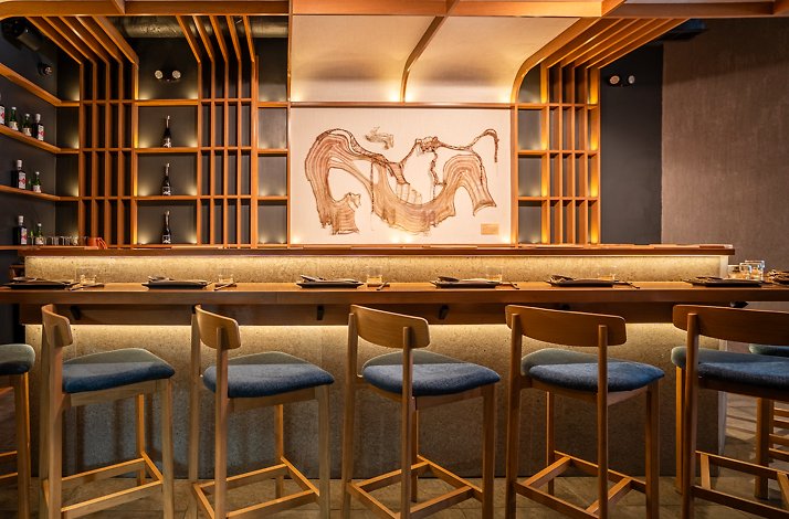 Chicago chef’s counter set for Japanese techniques with Peruvian flavors tastings at Akiro featuring a selection of alcohol on the shelves.