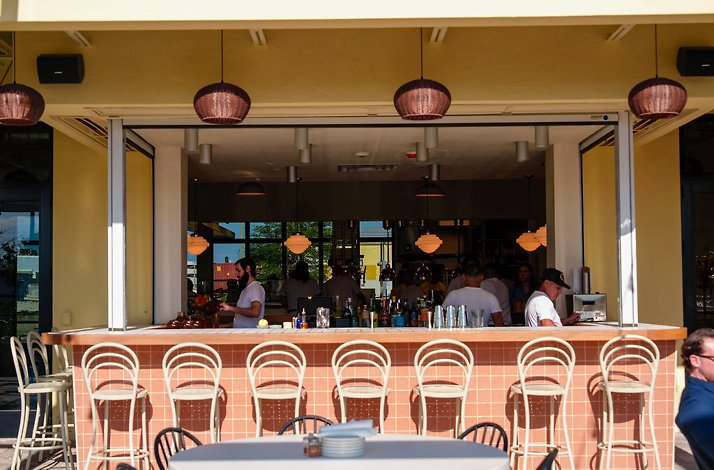 Outdoor Bar Bucce with white stools and bartenders