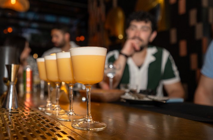Four pisco sour-style cocktails with foam tops lined up on Kayao Chicago's bar during an exclusive Mastercard tasting evening.