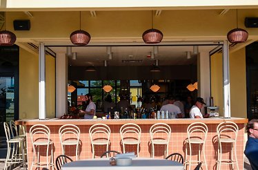 Outdoor Bar Bucce with white stools and bartenders