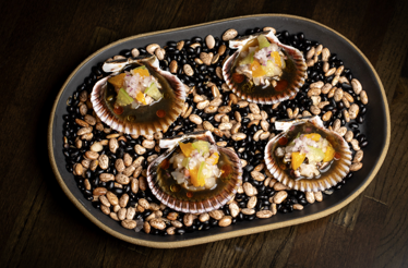 Four scallops served in shells atop mixed beans, topped with citrus, avocado, and red onion ceviche at Matilda, Chicago.