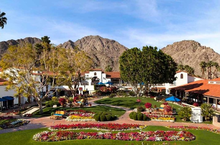This image shows the La Quinta Resort & Club, Curio Collection by Hilton, featuring its signature Spanish-inspired casitas and colorful courtyard gardens.
