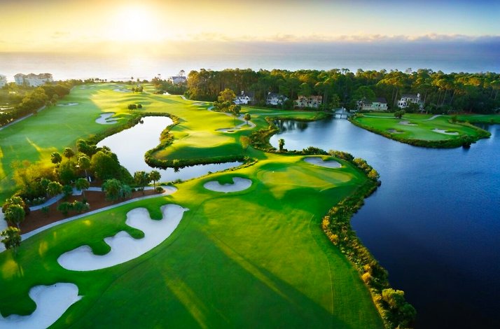 Aerial view of Palmetto Dunes Oceanfront Resort golf course, lakes, and ocean at sunrise.