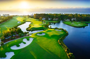 Aerial view of Palmetto Dunes Oceanfront Resort golf course, lakes, and ocean at sunrise.
