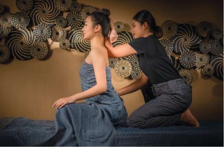 Interior of Thann Sanctuary, showing a worker giving a massage to a seated client.