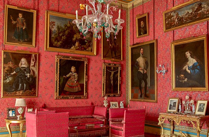 One of the exposition red rooms at the Palacio de Liria with paintings on display.
