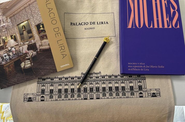 Palacio de Liria tote bag, official guide book, custom pen, and exhibition catalogue laid flat on a surface.