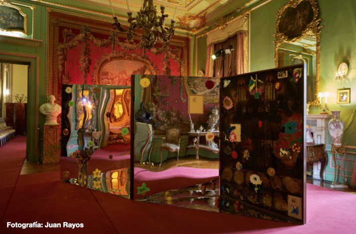 Artistic installation with mirrored panels and colorful decorations in a lavishly decorated room with red and green walls at Liria Palace.
