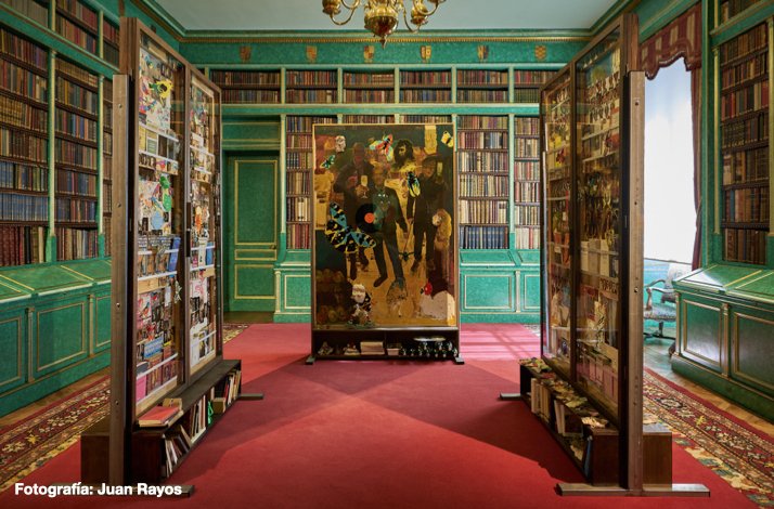 Library room at Liria Palace featuring green walls, shelves filled with books, and a central art piece with vibrant imagery.