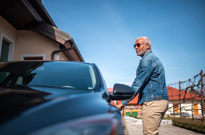 A man next to a rental vehicle from Hertz