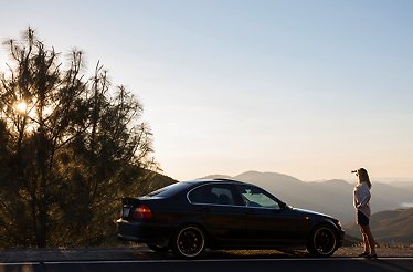 A BMW E46 3 Series parked on a panoramic overlook