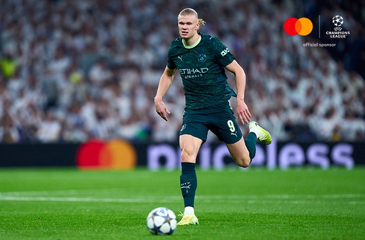 Manchester City forward controls the ball and drives forward during UEFA Champions League match.