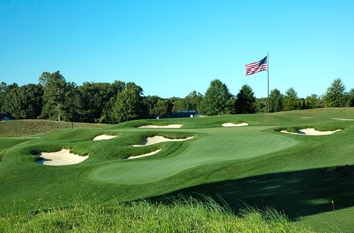 View at TPC Potomac’s golf courses landscape with a waving US flag on a flagpole.