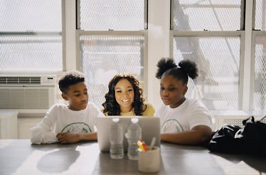 Roniesia Godfrey using education software to instruct two 21 Ethos students.