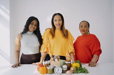 Ruby Millien, a founder of Ruby Spice Inc. with her mom Josette Haynes, and her daughter Amore Leary at the table where a selection of their produce is displayed.
