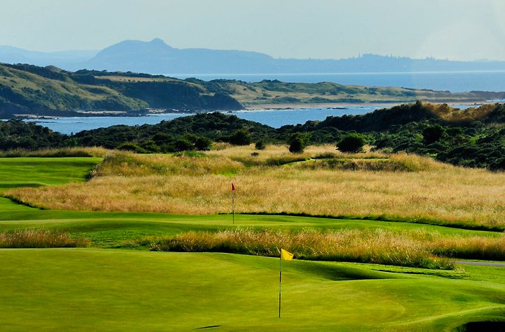 Coastal golf course with green fairways and ocean backdrop.