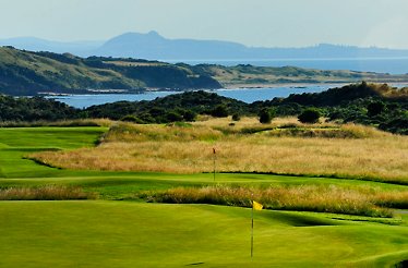 Coastal golf course with green fairways and ocean backdrop.