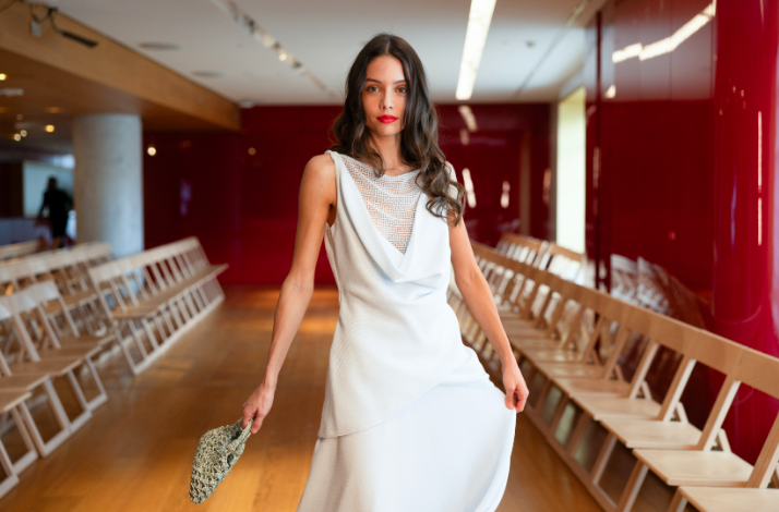 A female model wearing an evening white dress from a fashion collection at Galeries Lafayette Paris Haussmann 