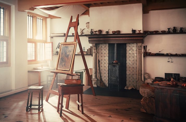 A view of the room with warm lightning featuring painting easel at Rembrandt House Museum in Amsterdam.