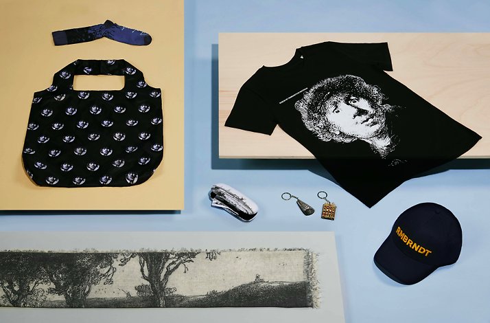 A themed black t-shirt, hat, and sunglasses displayed alongside each other on the neutral background.