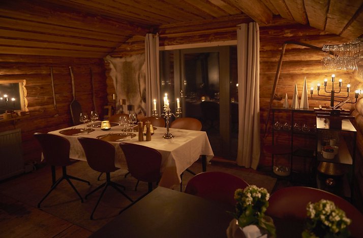 An elegant candle lit dining room in a log cabin