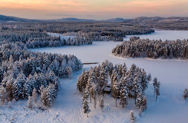 Birds eye view of a snow forest landscape with cabins