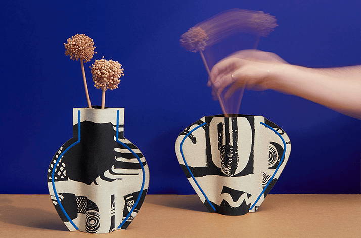 A pair of handmade vases on the blue background,  designed with the repurposed materials