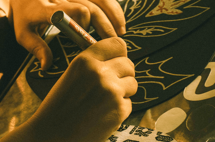 A close-up photo of the artist working on  a handcrafted item