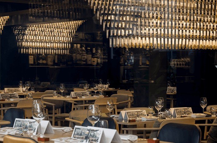 Le Du restaurant dining area with tables set with glasses and menus.