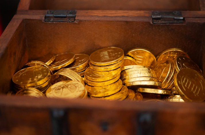 Open wooden chest filled with gold coins.
