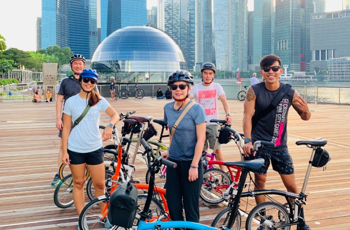 Private guided cycling tour participants photorgaphed with skyscrapers on the background 