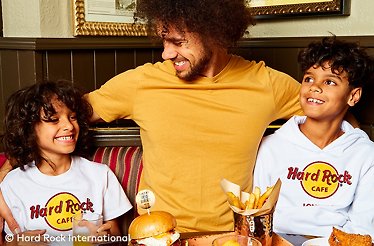 A parent and two kids enjoying a meal at the Hard Rock Cafe. © Hard Rock International.