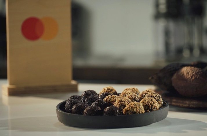 Dessert leftovers and pantry supplies are turned into a delicious dessert displayed on the table. Mastercard logo at the backend.