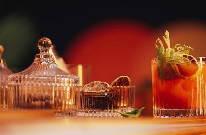 A glass of Grandma's Bloody Mary cocktail on the table, accompanied by a selection of dried fruits.